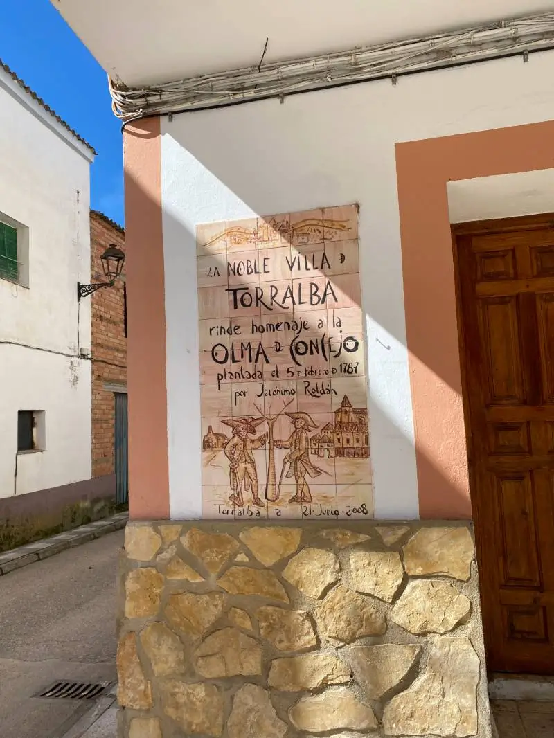 Mural de cerámica en Torralba que rinde homenaje a la Olma del Concejo, plantada en 1787, con ilustraciones históricas de la época.Villar de Domingo García - Villaconejos de Trabaque