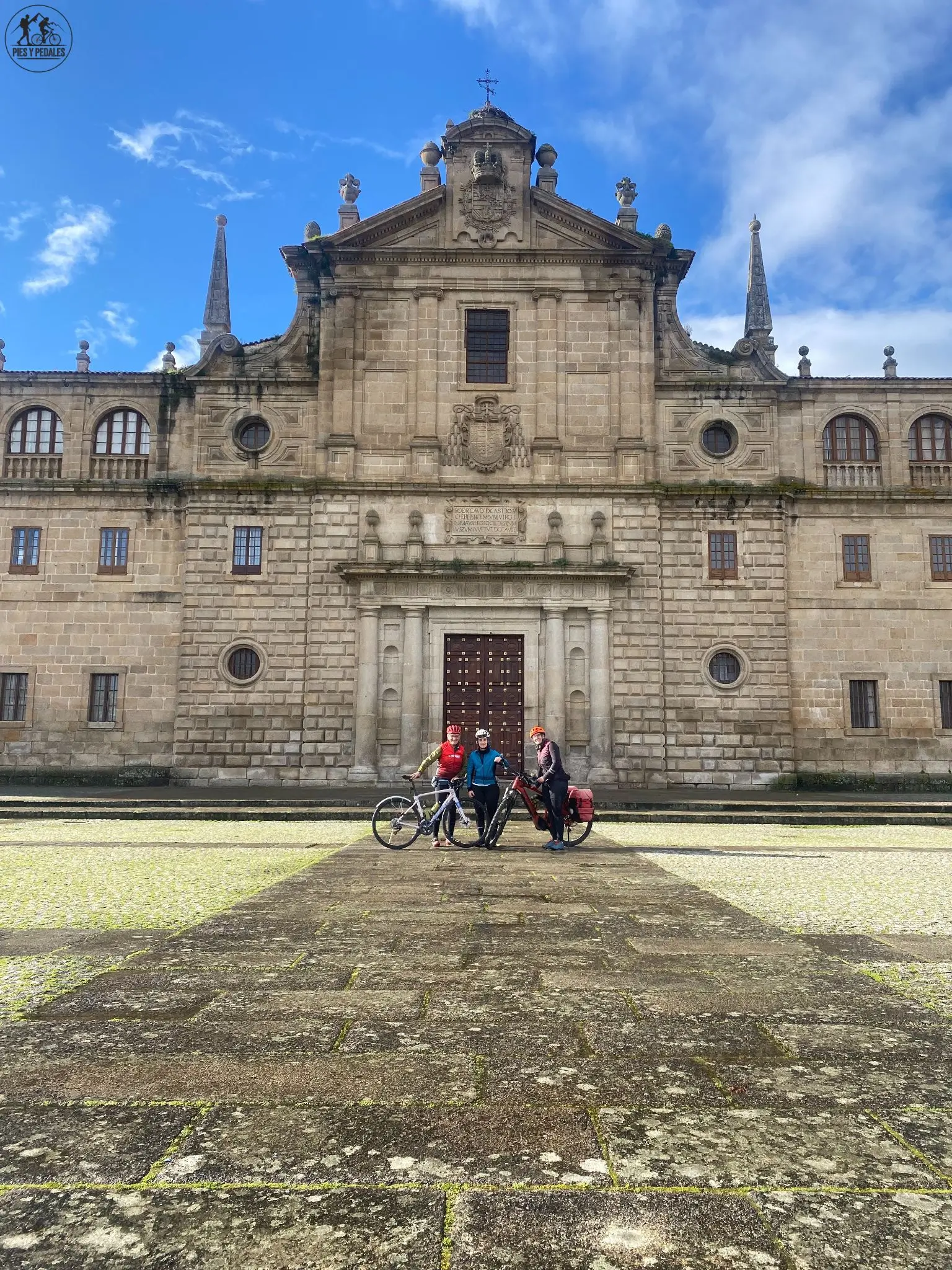 Ciclistas con alforjas frente al Monasterio de Santo Estevo, en la Ribeira Sacra