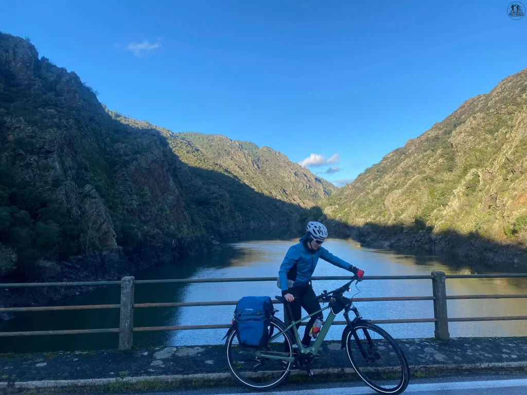 Ciclista con alforjas en un puente del Cañón del Sil durante la Ruta en Bicicleta por la Ribeira Sacra