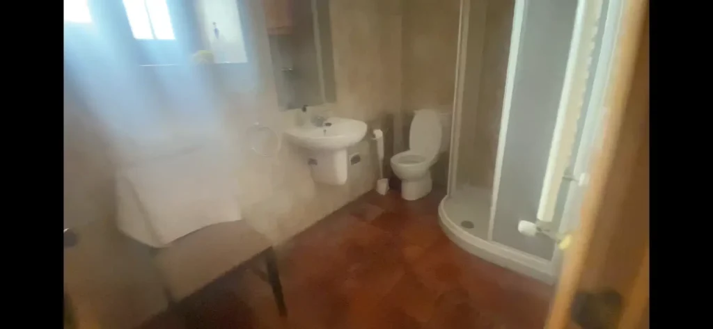 Baño con ducha, inodoro y lavabo en el Albergue La Corneja, Mecerreyes. Espacio limpio y funcional para peregrinos y ciclistas.