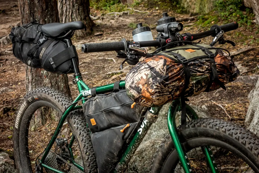 Bicicleta de bikepacking con bolsas de manillar, cuadro y sillín lista para travesías off-road