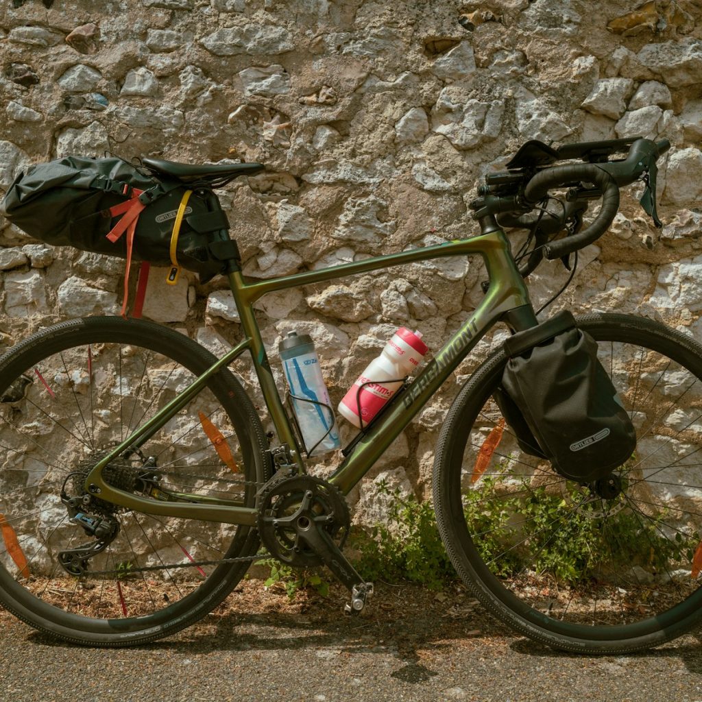 Bicicleta apoyada junto a un muro de piedra