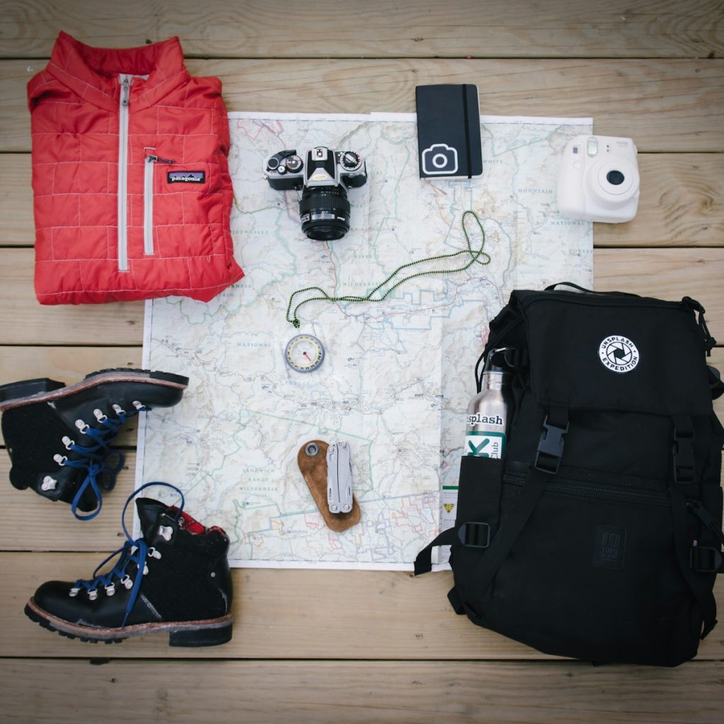 Mochila de montaña junto a unas botas y una cámara
