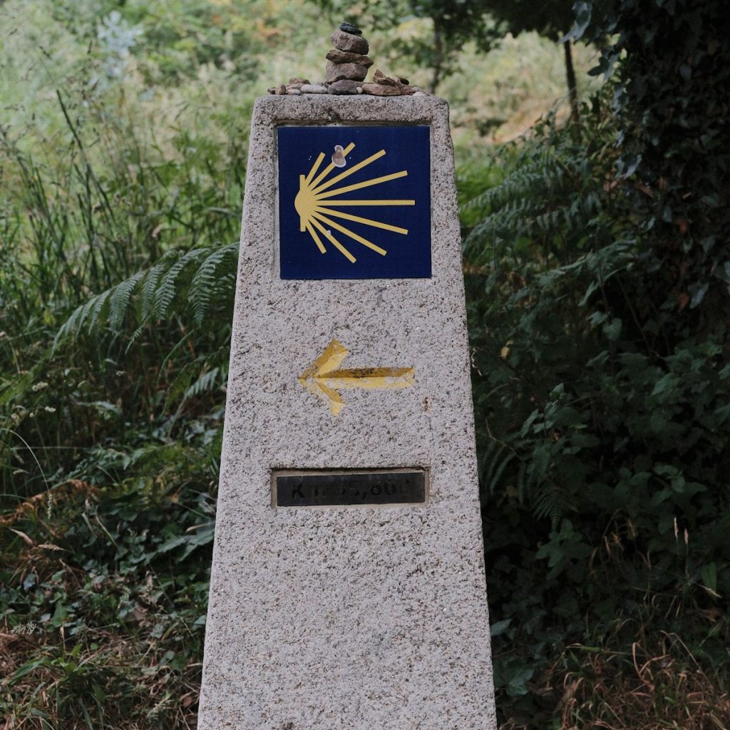 Mojón de piedra con la concha del Camino de Santiago