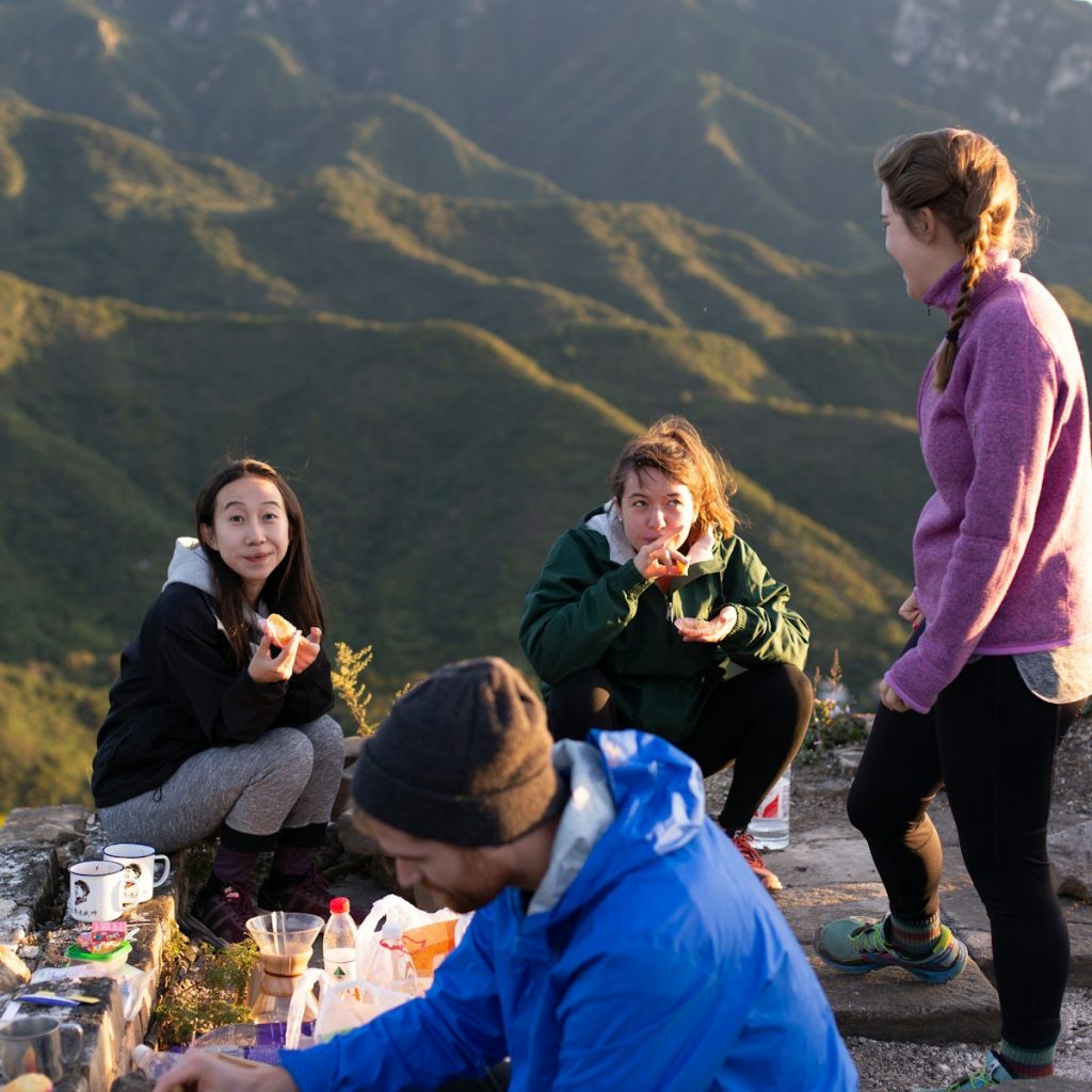 Caminantes comiendo en lo alto de una colina durante una ruta a pie
