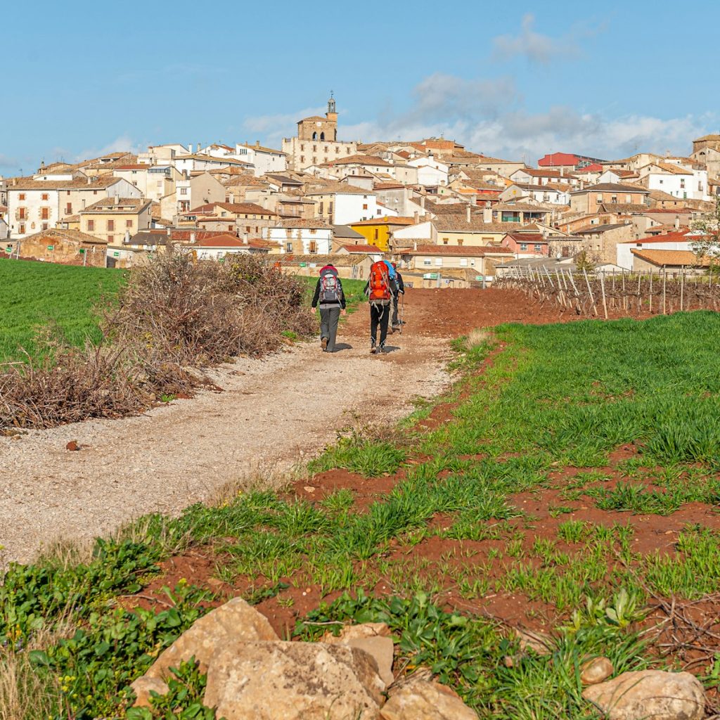 Dos peregrinos caminando por un camino de tierra